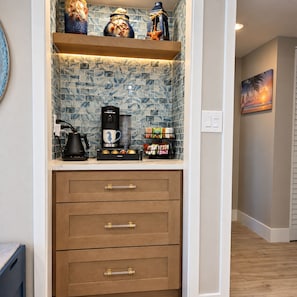 A kitchen area with a coffee maker, a mug, and a spice rack. - Premium Luxury Top-Floor Bayside Penthouse (Fort Myers)