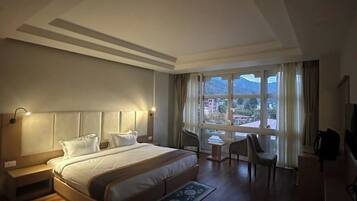 Habitación de hotel moderna con una cama grande, un escritorio y vistas a la ciudad.