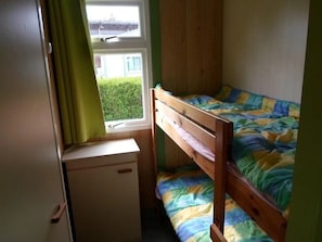 A bedroom with a bunk bed, a small desk, and a window with curtains. - Chalet 3 étoiles - Piscine  - ccbgea0 (La Chapelle-devant-Bruyères)