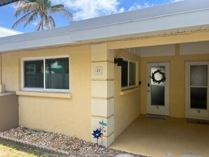 A residential building with numbered doors, a welcome sign, and a wreath on the door. - Casa Mar 11 - Standard Plus (Siesta Key)