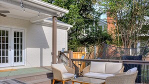 A covered outdoor seating area with wicker furniture and a patterned rug. - Augusta Luxe Retreat Minutes to Masters Private Backyard (Augusta)
