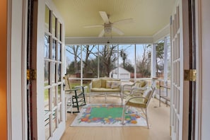 A covered porch with wicker furniture, a ceiling fan, and a view of the surrounding landscape. - Classic 5BR Davidson Retreat Walk Downtown Pet-friendly (Davidson)