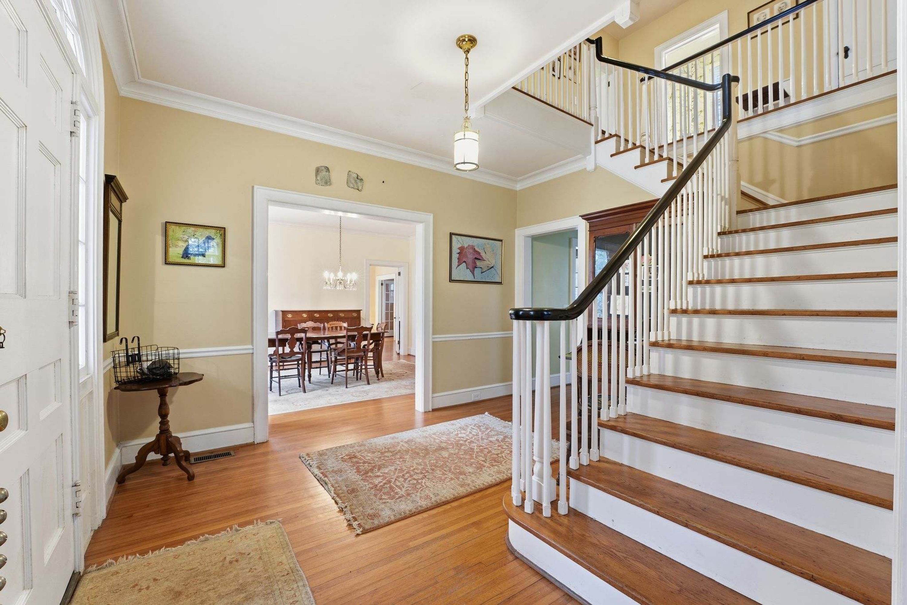 A staircase with white railings and wooden steps leading to a second floor.