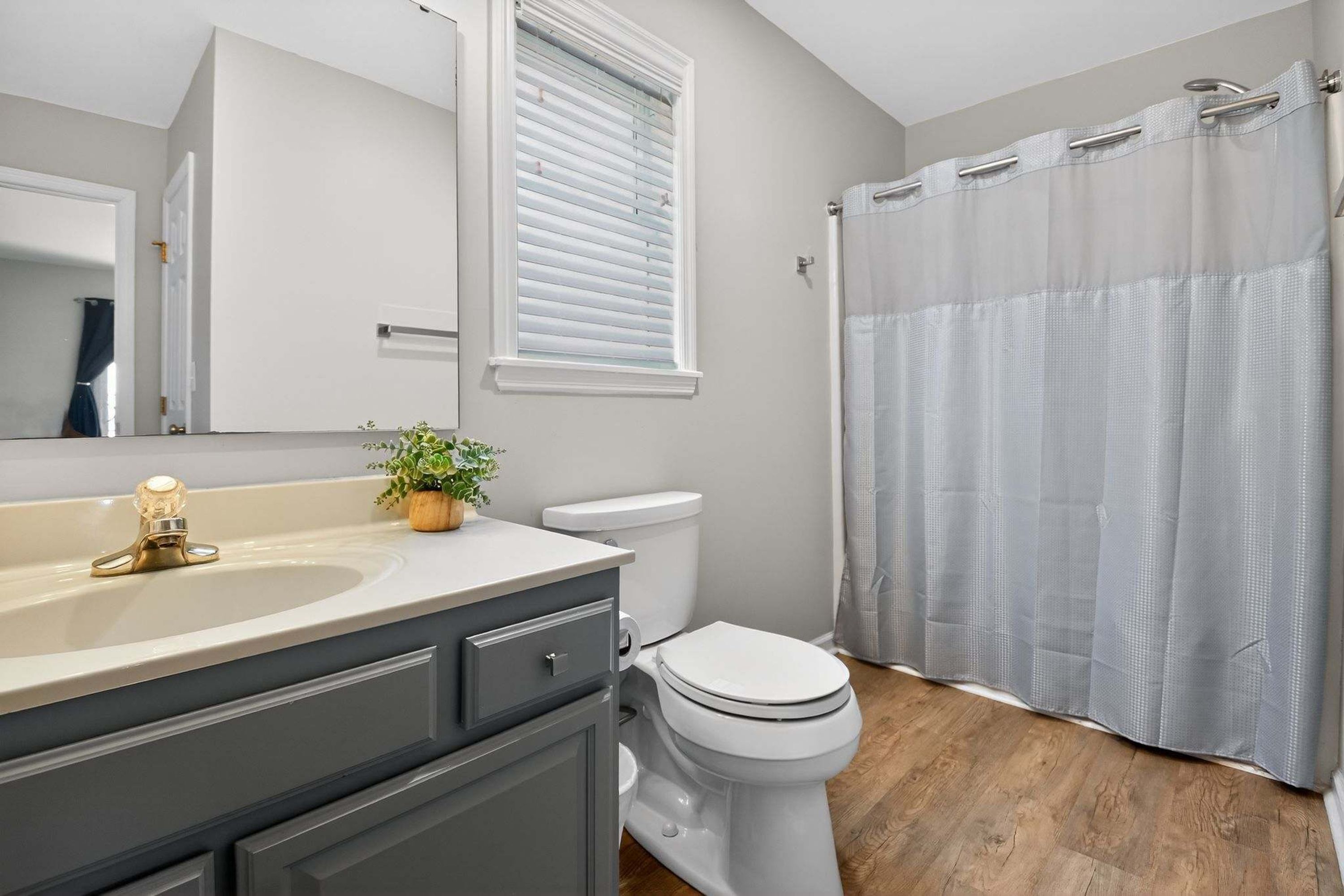 Une salle de bain équipée d’un lavabo, de toilettes et d’un rideau de douche.
