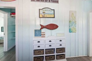 A wall with a framed sign, a fish decoration, and a signboard with beach-related text. - Beach Life 2 - Sunshine Lane (Treasure Island)