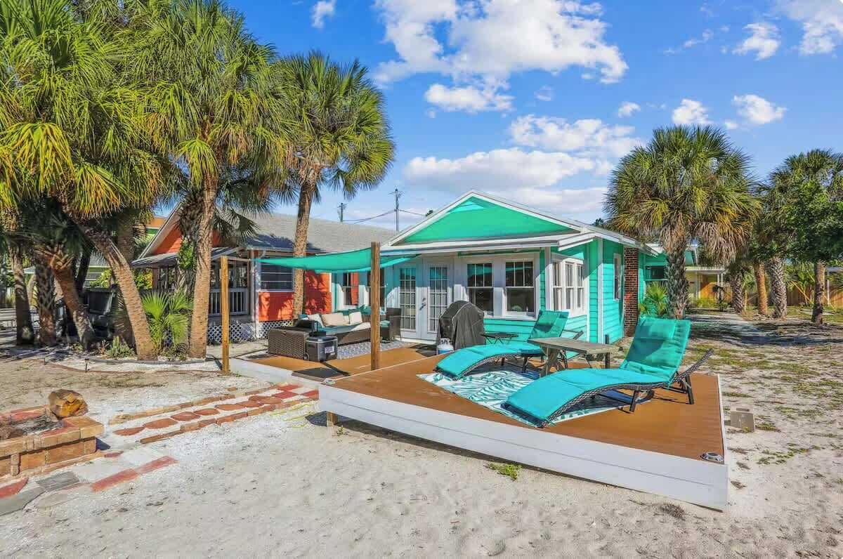 Una propiedad frente a la playa con un patio cubierto, mobiliario exterior y zona de piscina.