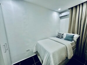 Una camera da letto con un letto, un armadio e un condizionatore d'aria.