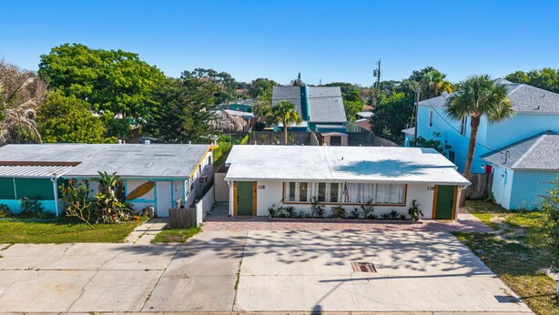 Zona residencial con casas, un camino pavimentado y vegetación circundante.