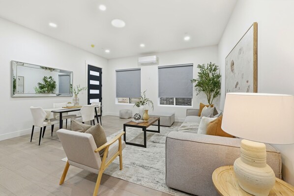 A modern living room with a sofa, chairs, a coffee table, and a lamp.