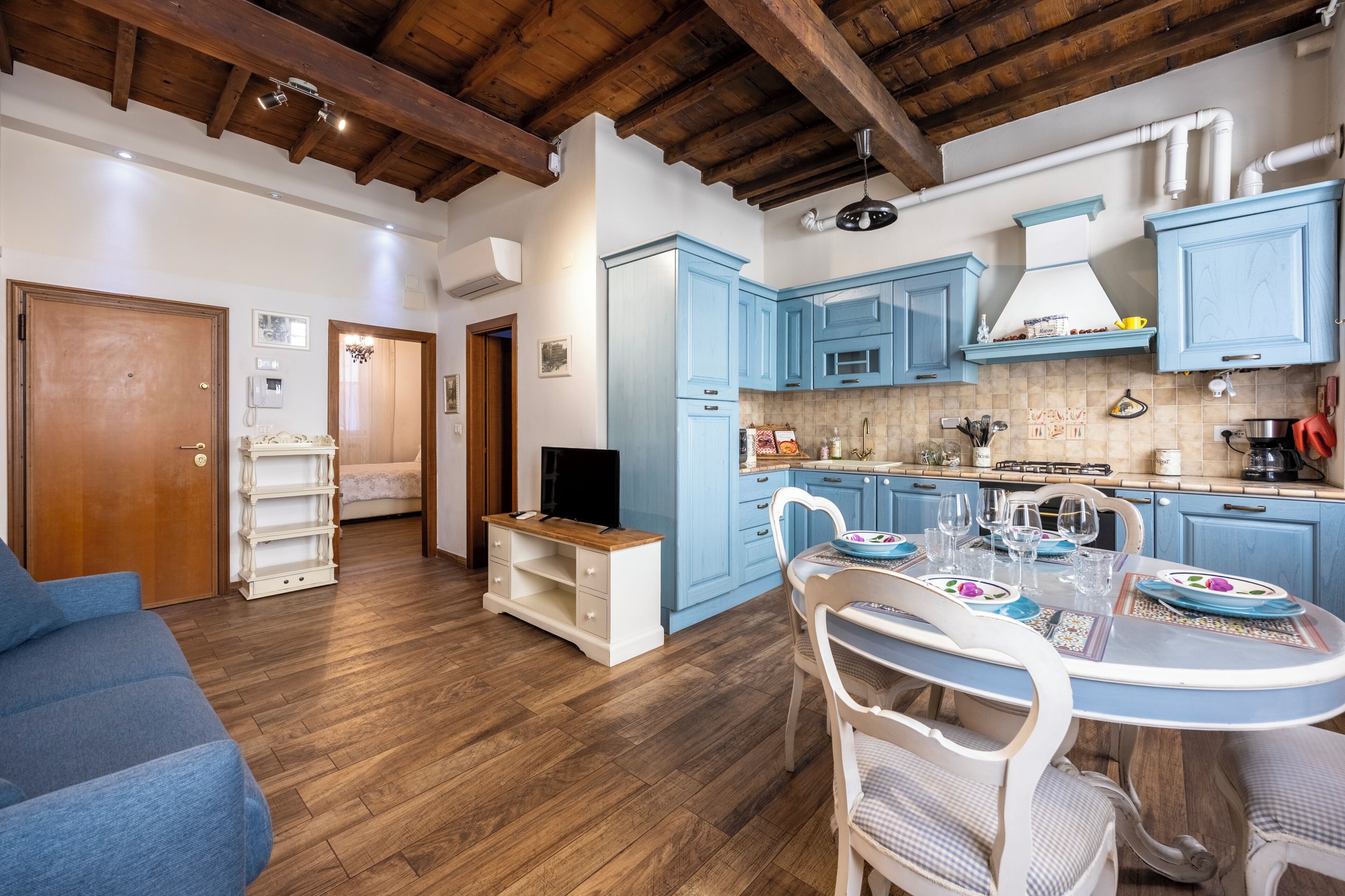 Un espace de vie compact comprenant une cuisine, un coin repas et une petite chambre.