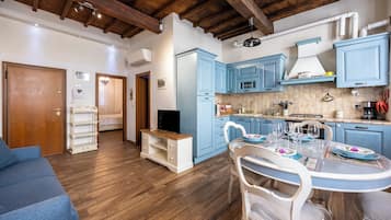A compact living space with a kitchen, dining area, and a small bedroom.