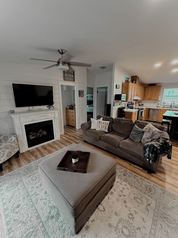 A living room with a fireplace, a television, a sofa, and a coffee table.
