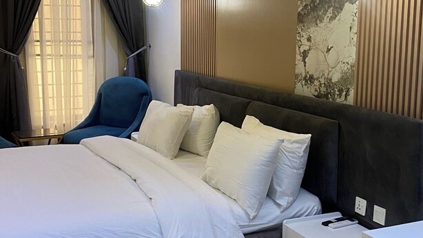Un dormitorio moderno con una cama grande, un escritorio y una silla.