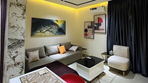 Una sala de estar moderna con sofá, mesa de centro y sillón.