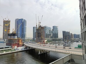 Eine Skyline mit Hochhäusern, einer Brücke über dem Wasser und einer Marina mit Booten.