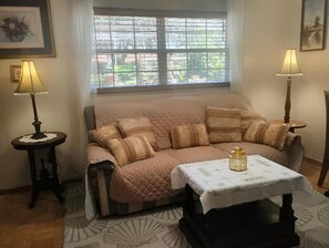 Una sala de estar acogedora con un sofá, una mesita y dos lámparas.