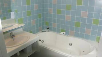 Een badkamer met een wit wastafel, een bad en een spiegel.