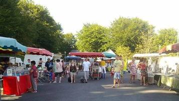Een markt in de open lucht met verschillende kraampjes en mensen die rondkijken.