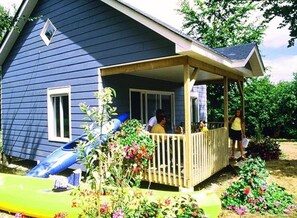 A house with a porch, a slide, and a garden.
