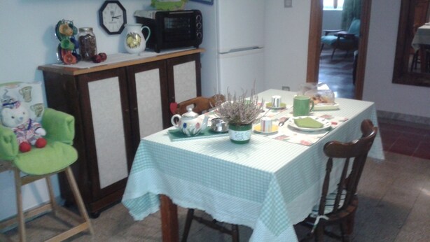 A dining area with a table set for two, a clock, and a microwave on the wall. - At Anita's, a bright apartment with easy access to the historic center. (Roma)