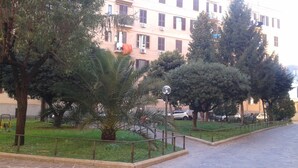 A paved pathway with a metal railing, surrounded by greenery and trees. - At Anita's, a bright apartment with easy access to the historic center. (Roma)