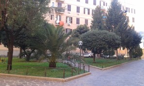 A paved pathway with a metal railing, surrounded by greenery and trees. - At Anita's, a bright apartment with easy access to the historic center. (Roma)