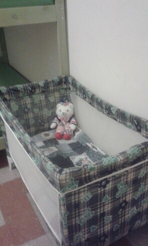 A crib with a Hello Kitty design, positioned against a wall in a room with a tiled floor. - At Anita's, a bright apartment with easy access to the historic center. (Roma)