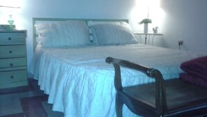 A bedroom with a bed, a chair, a dresser, and a bedside table. - At Anita's, a bright apartment with easy access to the historic center. (Roma)