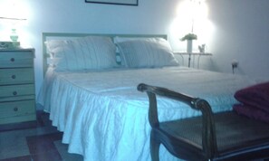 A bedroom with a bed, a chair, a dresser, and a bedside table. - At Anita's, a bright apartment with easy access to the historic center. (Roma)