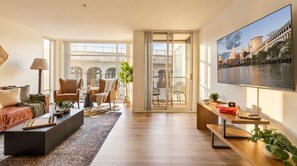 Un salon spacieux avec une grande fenêtre, un canapé, une table basse et une bibliothèque.