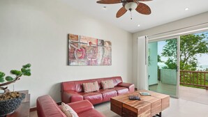Ein modernes Wohnzimmer mit einem roten Ledersofa, einem Holztisch und einem Gemälde an der Wand.