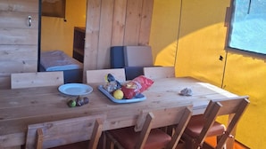 A wooden dining table with chairs, a bench, and a window with a view. - Couple Poco Novo Glamping Lodge in Loulé Algarve for 1-2 people (Loulé)