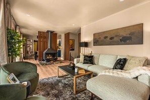 Een moderne woonkamer met een open haard, een zithoek en een eethoek.