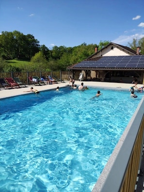 A swimming pool with people swimming and lounging.