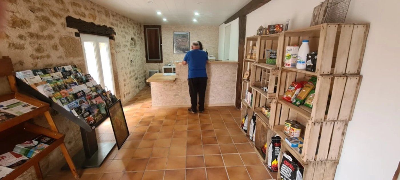 Une pièce avec un sol carrelé, un comptoir en bois et des étagères remplies de divers produits alimentaires.