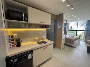 Uma cozinha moderna equipada com micro-ondas, máquina de café e lava-louças.
