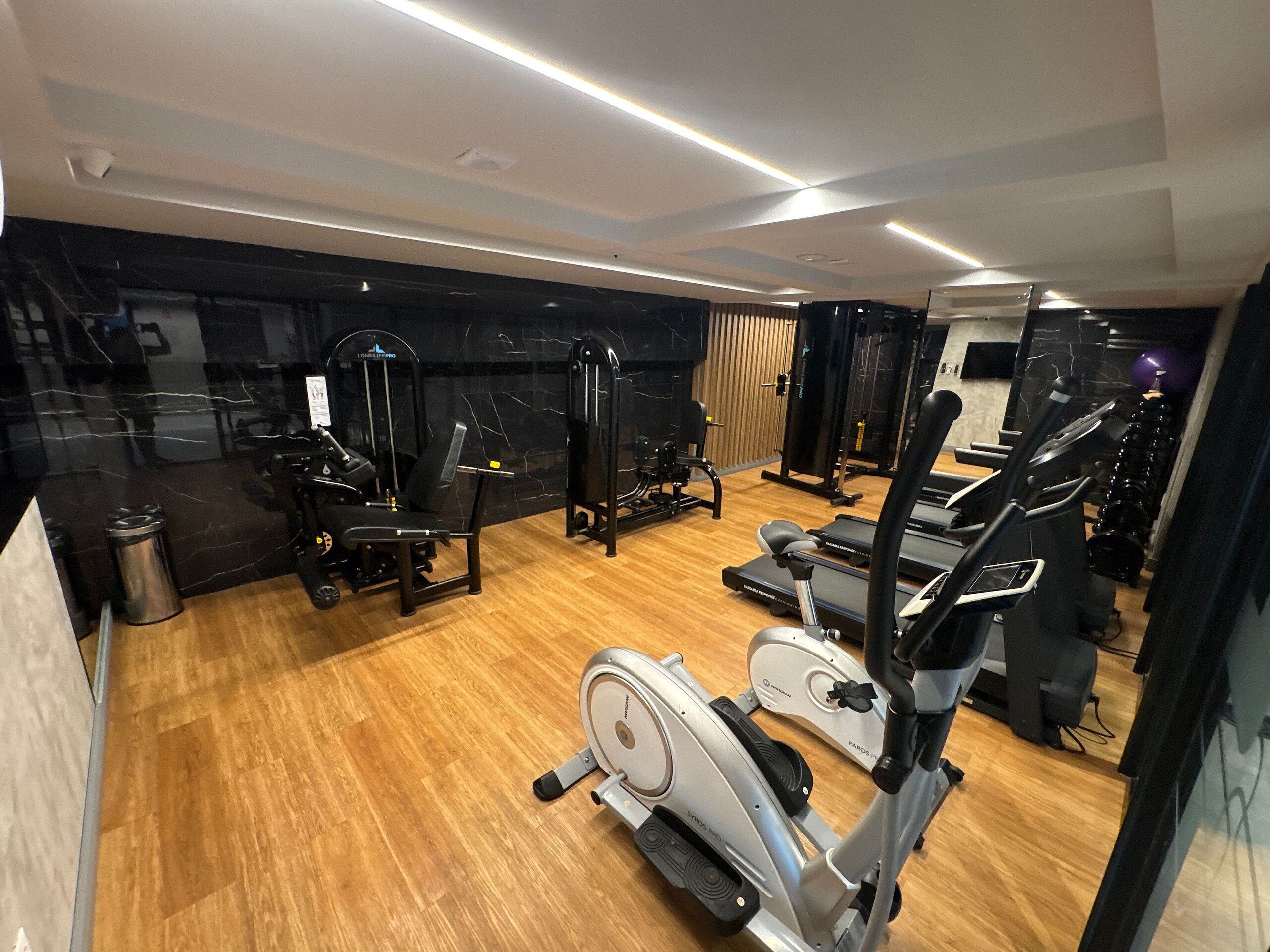 A gym with various exercise equipment, including treadmills and weight machines.