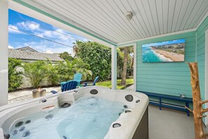 A hot tub with a view of a beach, surrounded by greenery and blue chairs. - Sleeps 10 • Hot tub • Games • 5 Mins to Beach (Jupiter)