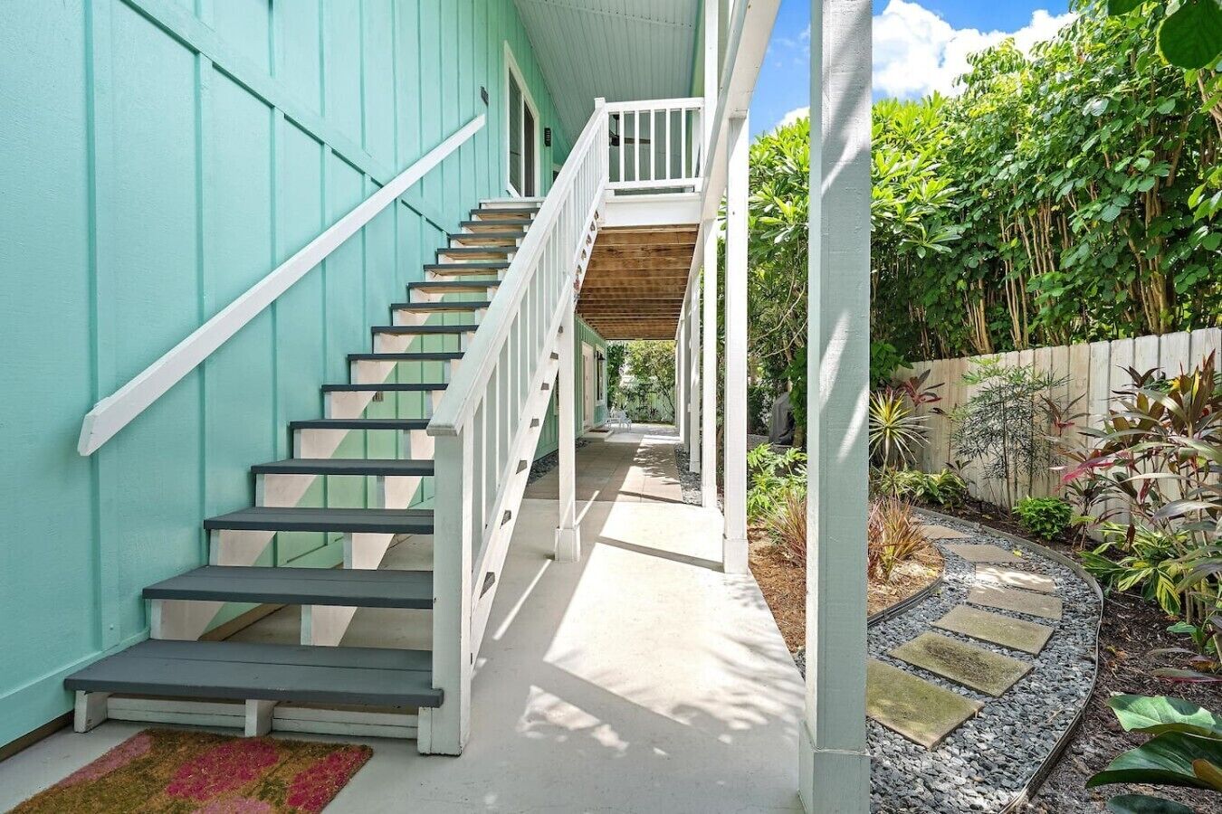 A staircase leading to a covered porch with a view of a garden.