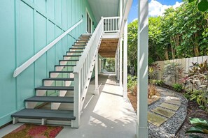 Eine Treppe führt zu einer überdachten Veranda mit Blick auf einen Garten.