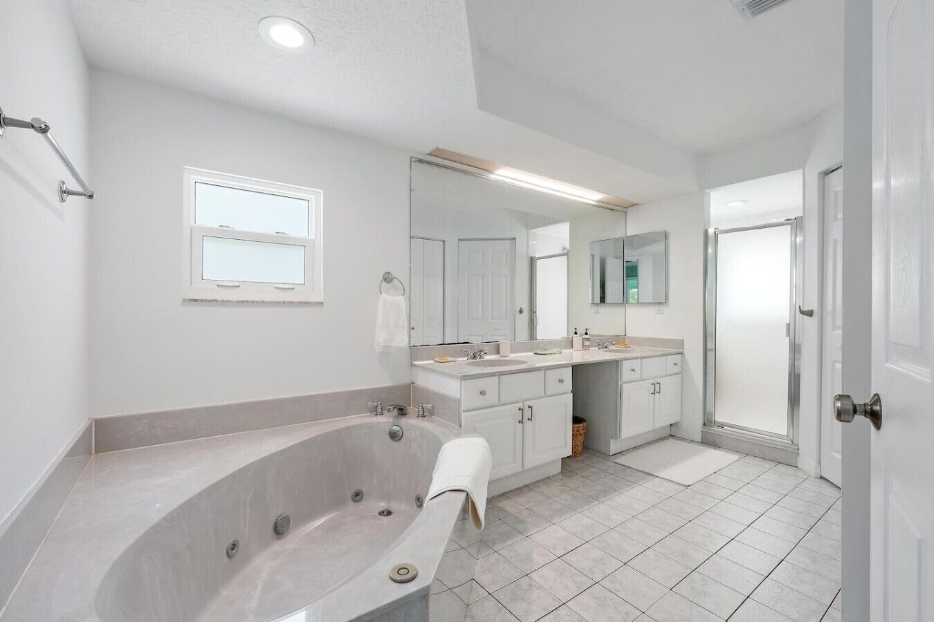 A modern bathroom with a freestanding bathtub, a double sink vanity, and a walk-in shower.
