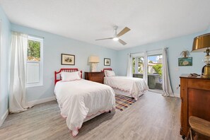 A bedroom with two beds, a ceiling fan, a window with curtains, and a wooden dresser. - Sleeps 10 • Hot tub • Games • 5 Mins to Beach (Jupiter)