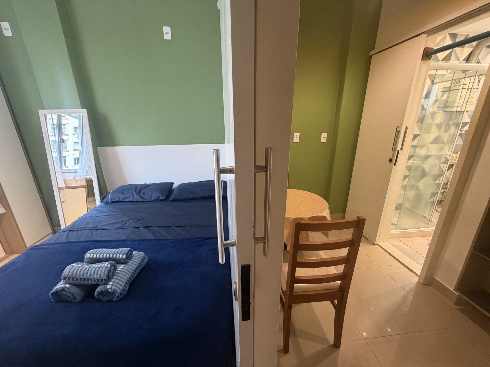 A bedroom with a bed, a chair, and a wardrobe.