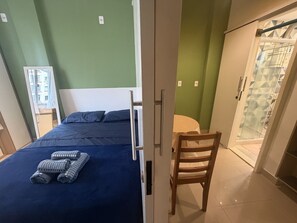 Ein Schlafzimmer mit einem Bett, einem Sessel und einem Kleiderschrank.