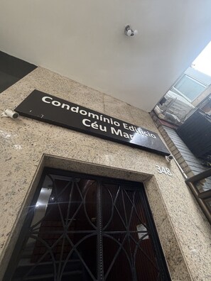 Ein Gebäudeeingang mit einem Schild, auf dem 'Condomínio Edificio Céu Marcio' steht, und der Zahl '348' über der Tür.