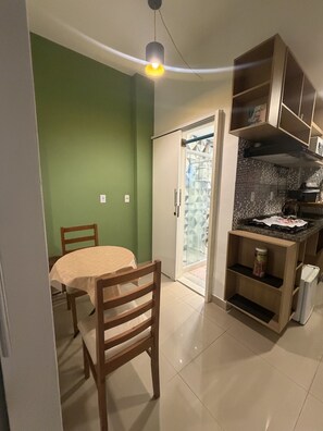 Eine kompakte Küche mit Essbereich, einem Einbauofen und einem Kühlschrank.
