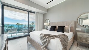 A modern hotel room with a large bed, a balcony with a view of the sea, and a well-lit space. - Encantame Soleil (Puerto Peñasco)