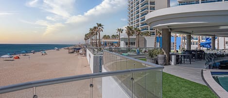 A resort with a beach, a pool, and a view of the ocean.