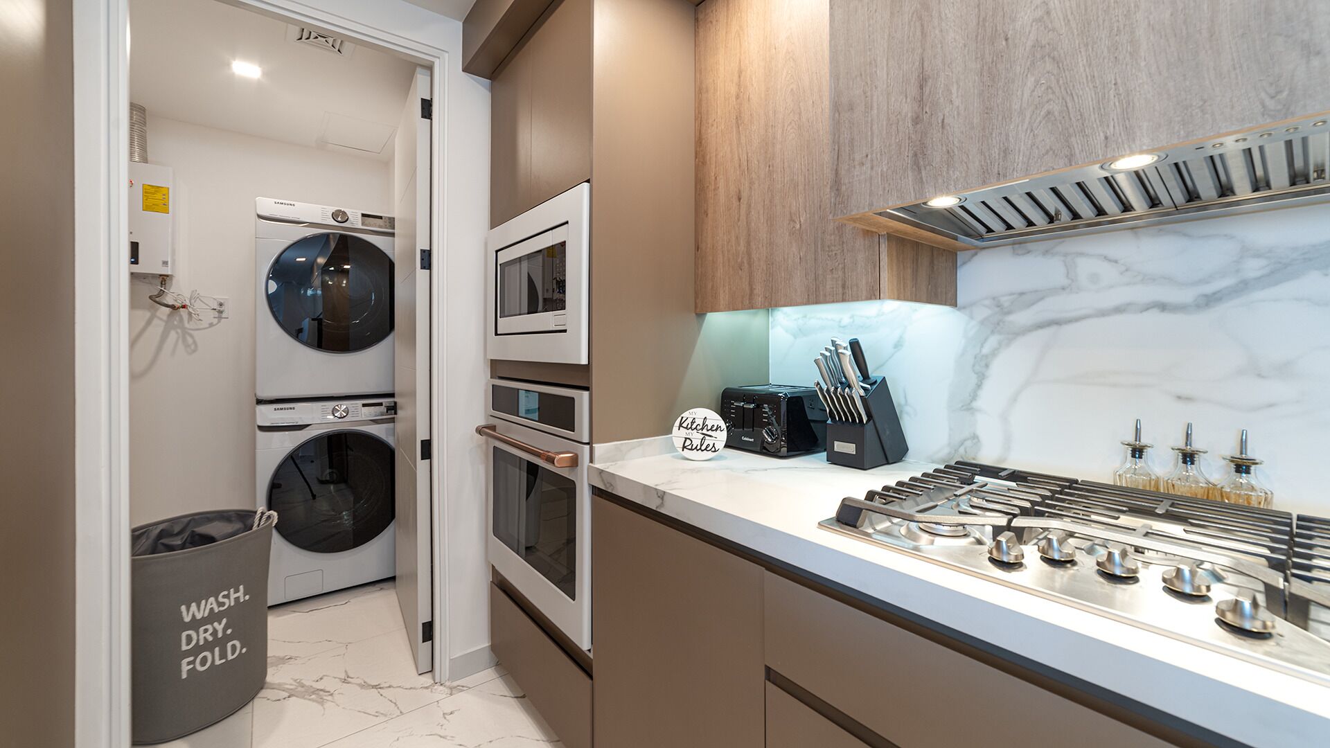 A modern kitchen with a built-in oven, microwave, and a gas stove.