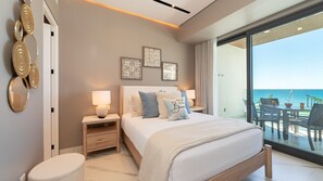 A modern bedroom with a large bed, bedside tables, and artwork on the wall. - Encantame Soleil (Puerto Peñasco)